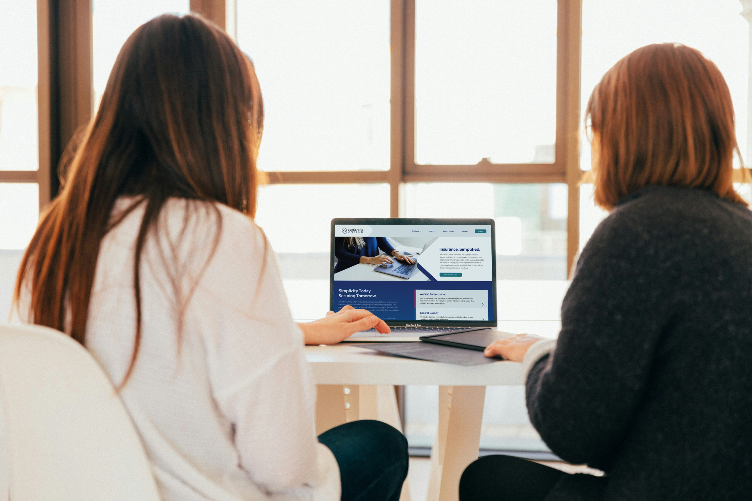 Two women looking at the Berkshire United website on a computer.